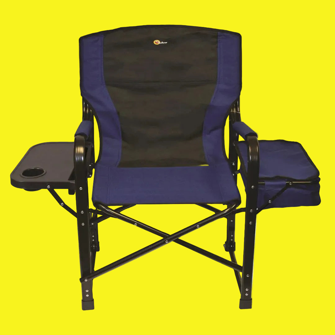 A blue and black folding director's chair with an insulated cooler and a built-in drink holder, set up outdoors.