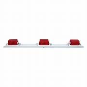 A rectangular clearance light bar with three red lenses on a white surface.
