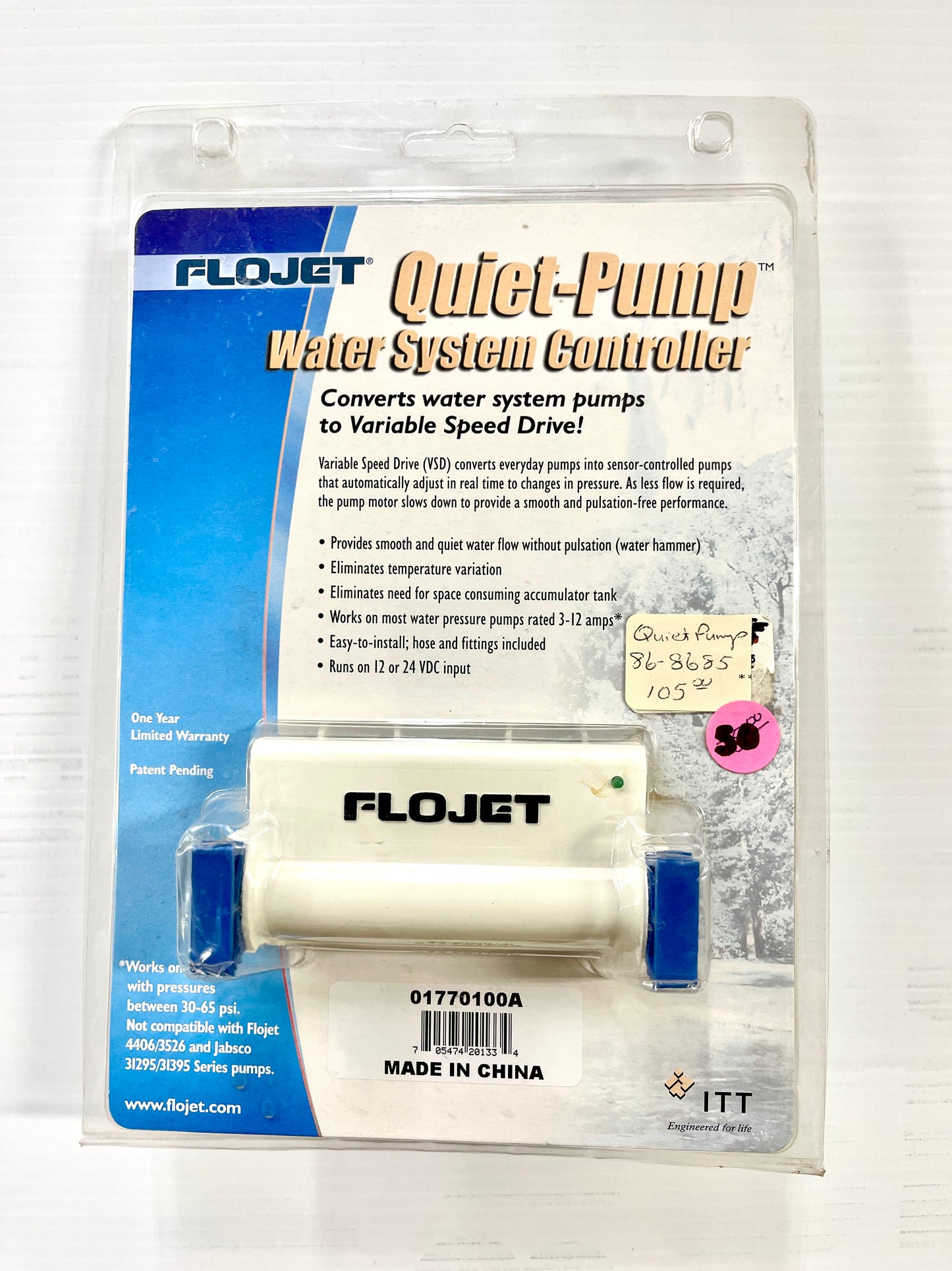 Packaging for Flojet Quiet-Pump Water System Controller with product visible through a clear plastic window, displaying the white and blue pump controller with instructions and hardware included.