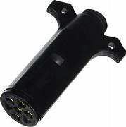 A black 7-way trailer wiring connector with a round plug on one side and labeled specifications on the side facing the camera.