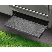 A castle gray step rug fitted on a black outrigger step, with a grass-like area at the bottom and a black threshold.