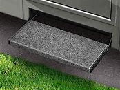 A castle gray step rug fitted on a black outrigger step, with a grass-like area at the bottom and a black threshold.