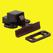 A concealed positive catch for cabinet doors, consisting of a dark brown rectangular component and a lighter brown mounting bracket with screw holes.