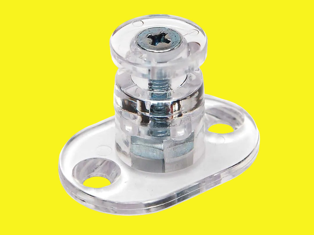 A clear plastic pleated shade hold down used to secure window shade tension cords.