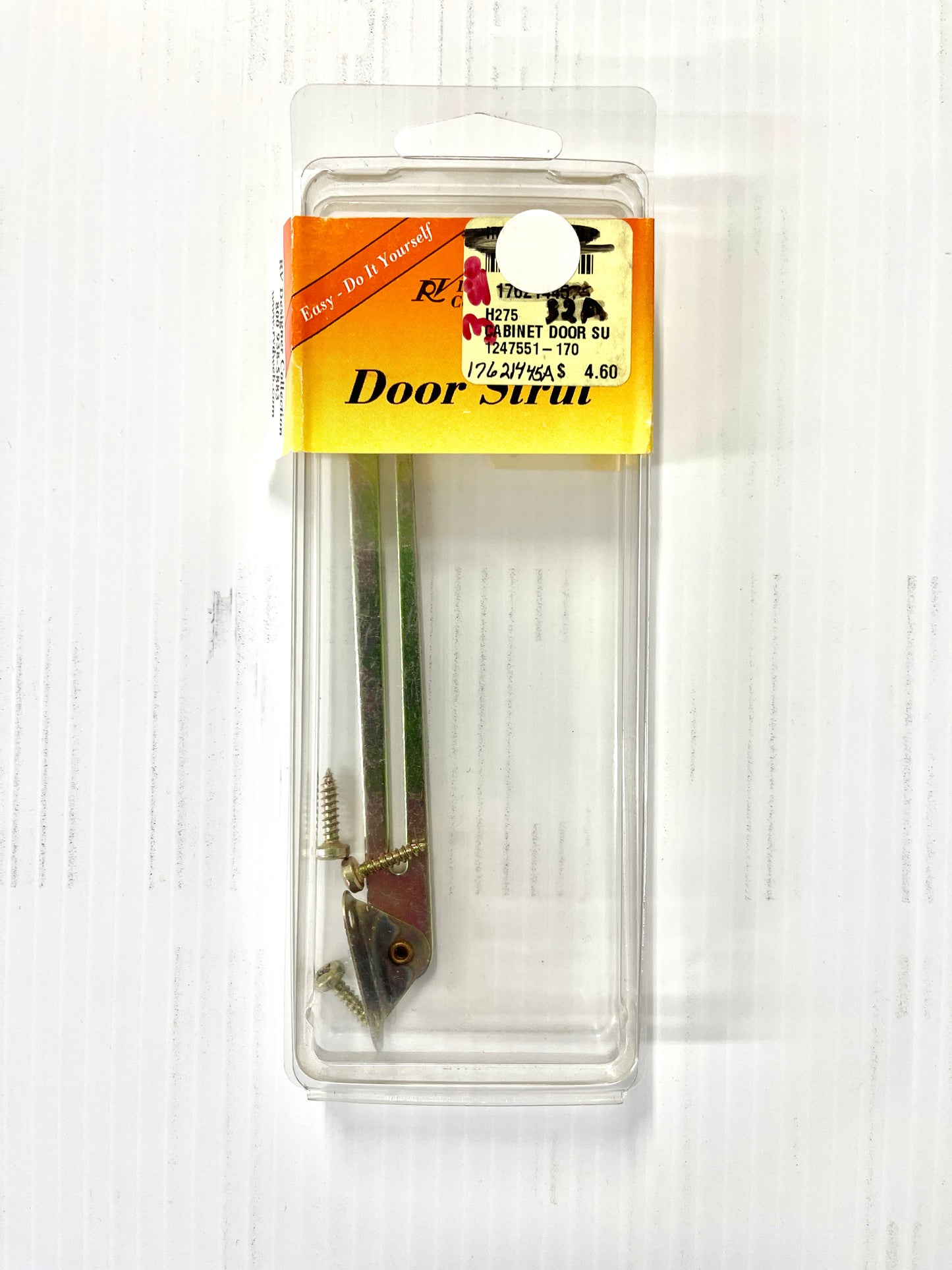 RV Designer Door Strut product packaging, featuring a metal strut with a plastic packaging that includes a yellow label with text.