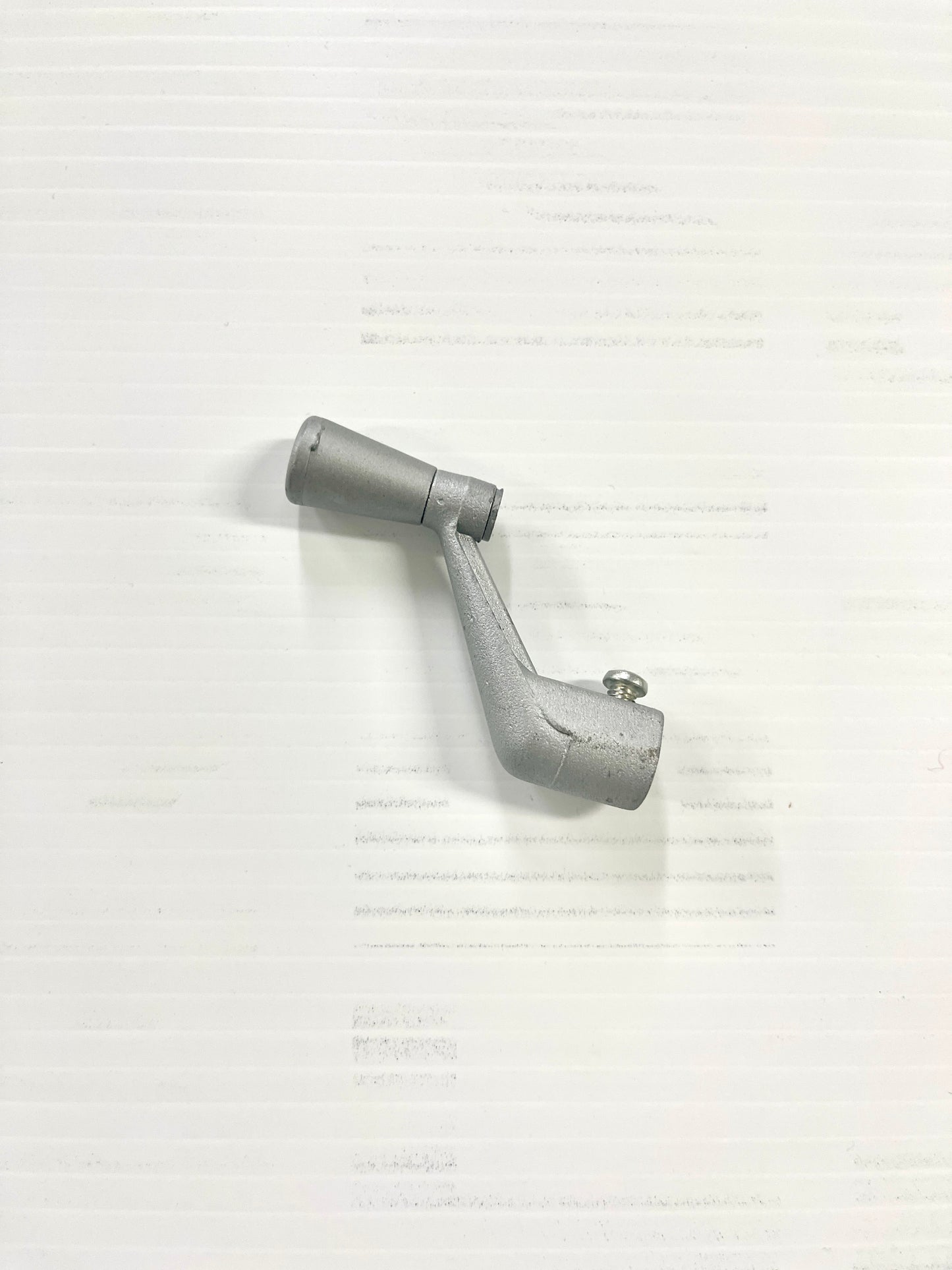 A single metal window crank against a plain background.