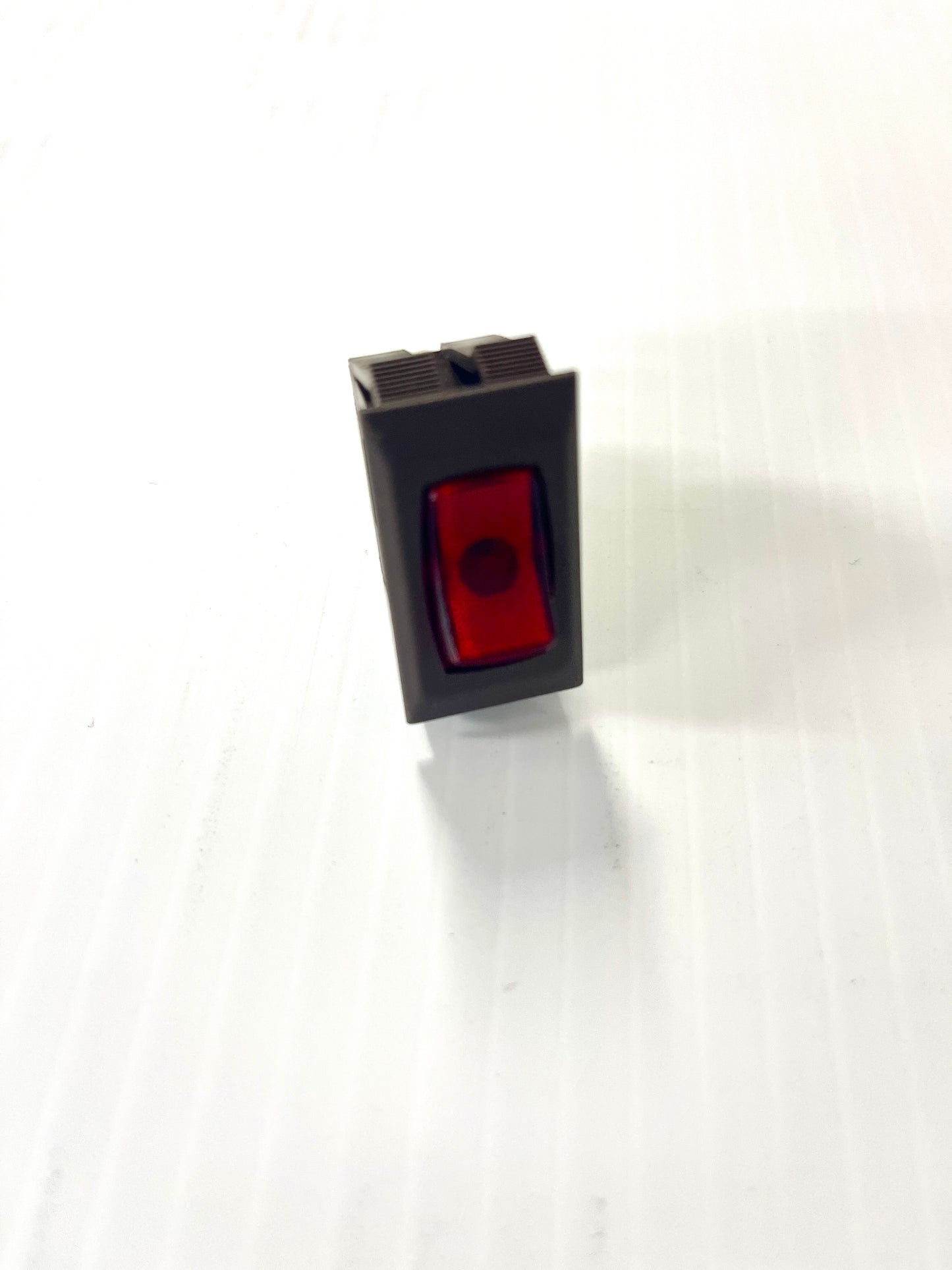 A single brown and red switch with a visible light-illuminated red side, placed on a light background.