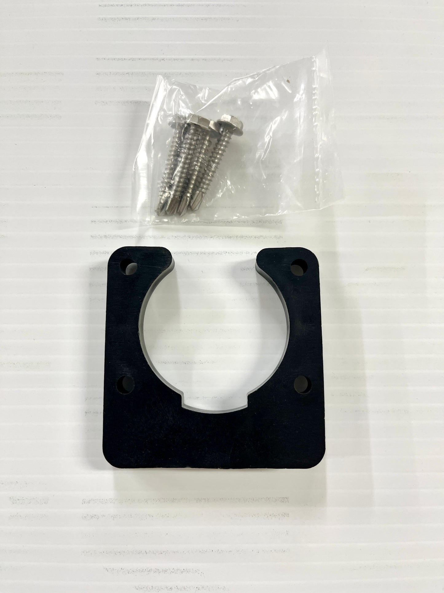 A black plastic trailer wiring bracket with a mounting screw attached on top, placed on a white background.