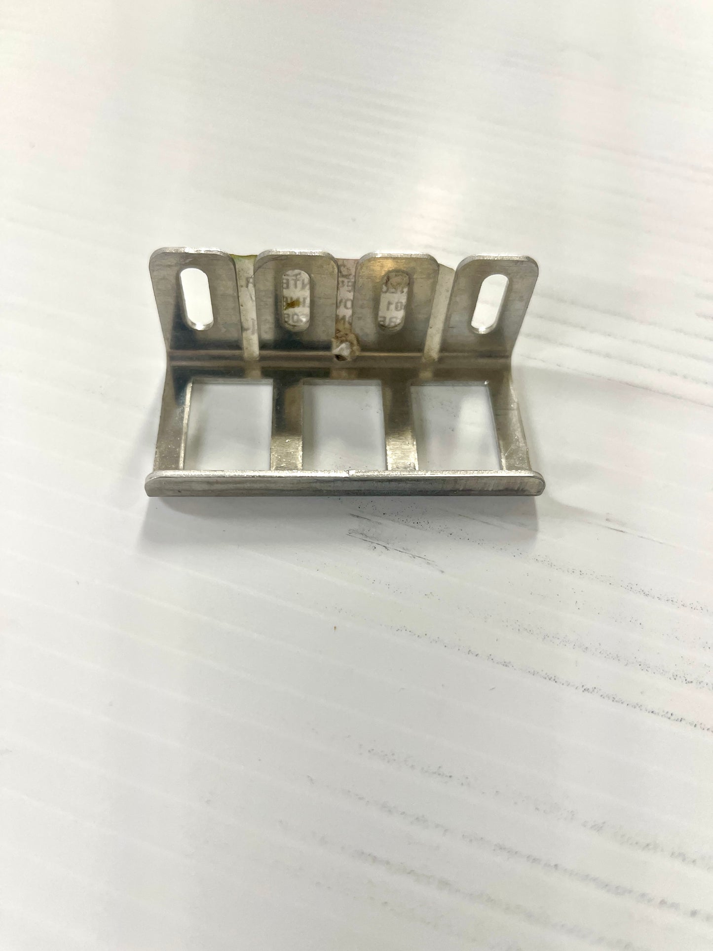 A metal switch plate cover mounting bracket.