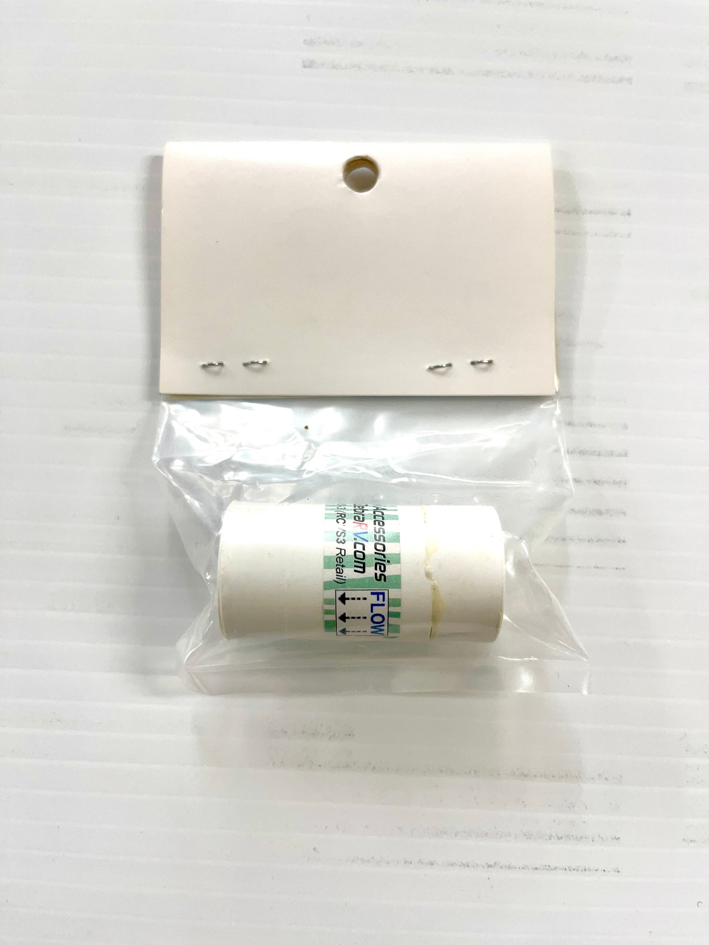 A white 3/8 inch female pipe thread check valve, placed in a clear plastic packaging with a hangtag.