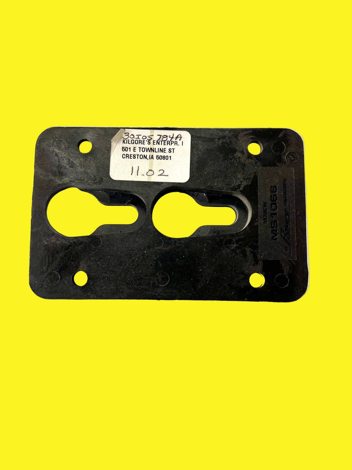 A black plastic TV wall mount bracket with two holes for mounting and a label in the upper right corner.