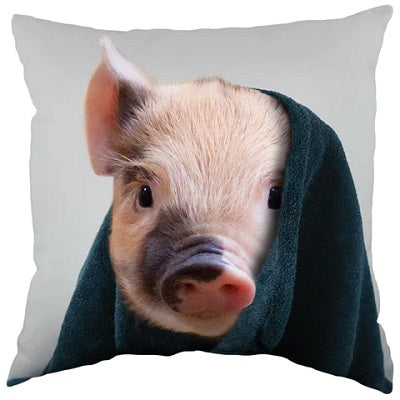 A pillow with an image of a pig's face peeking out from under a blue blanket.