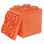 A set of orange, interlocking leveling blocks arranged in a pyramid shape.