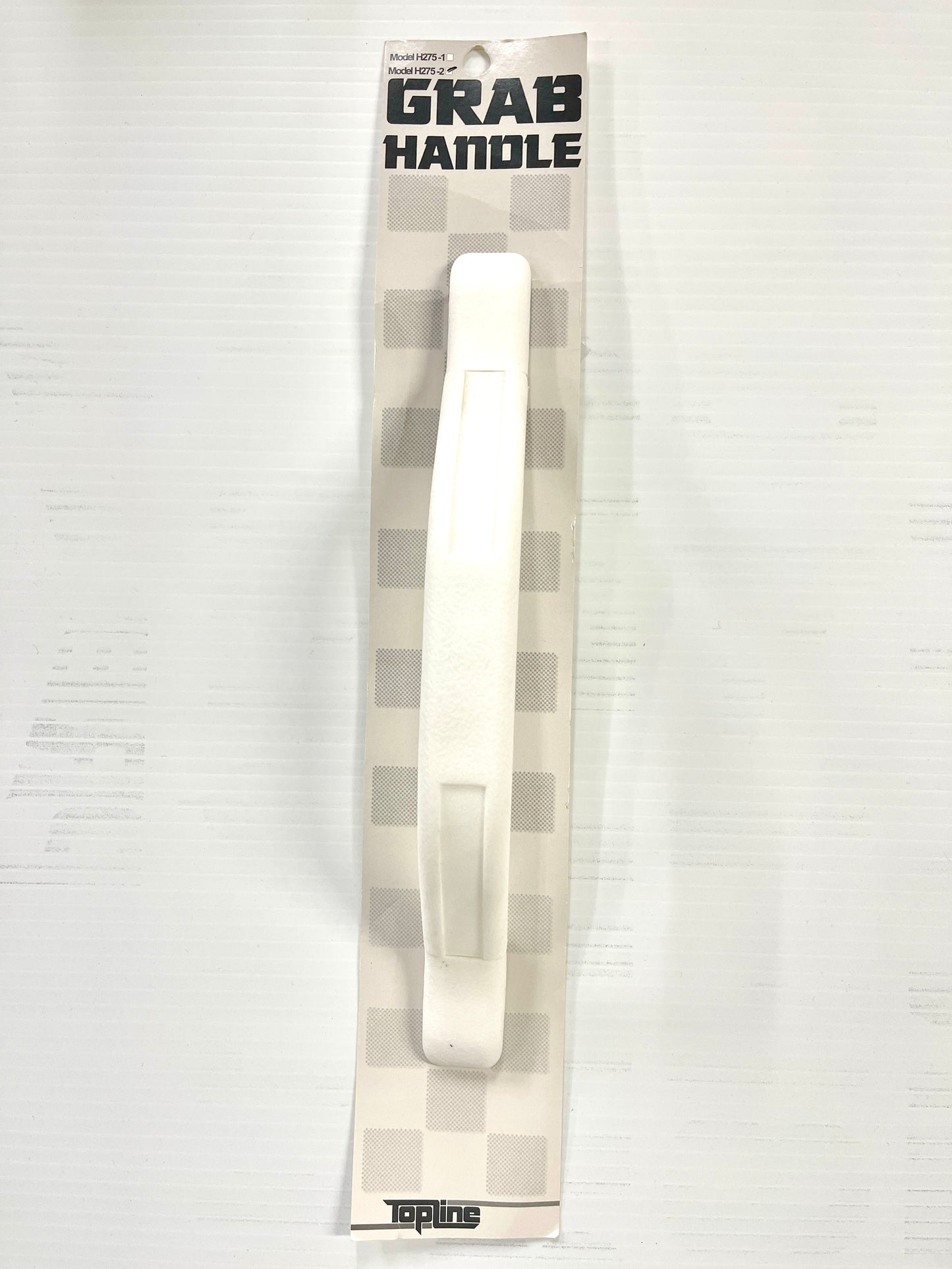 A white grab handle, packaged in a card with 'GRAB HANDLE' text and the brand name 'TopLine'.