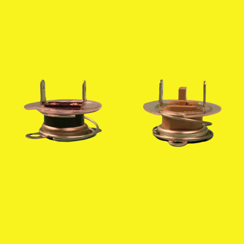 Two metal water heater thermostats, one facing up and the other facing down, against a yellow background.