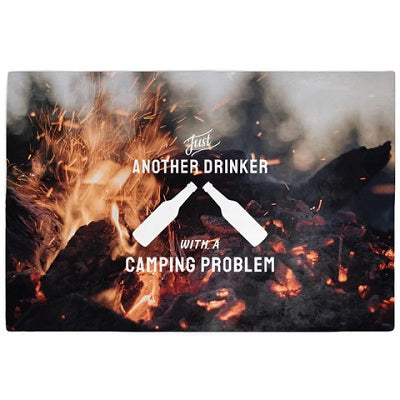 A rectangular throw blanket with a camping theme and a humorous text pattern that reads 'Another Drinker With A Camping Problem' along with a graphic of two bottles of beer at a campfire.