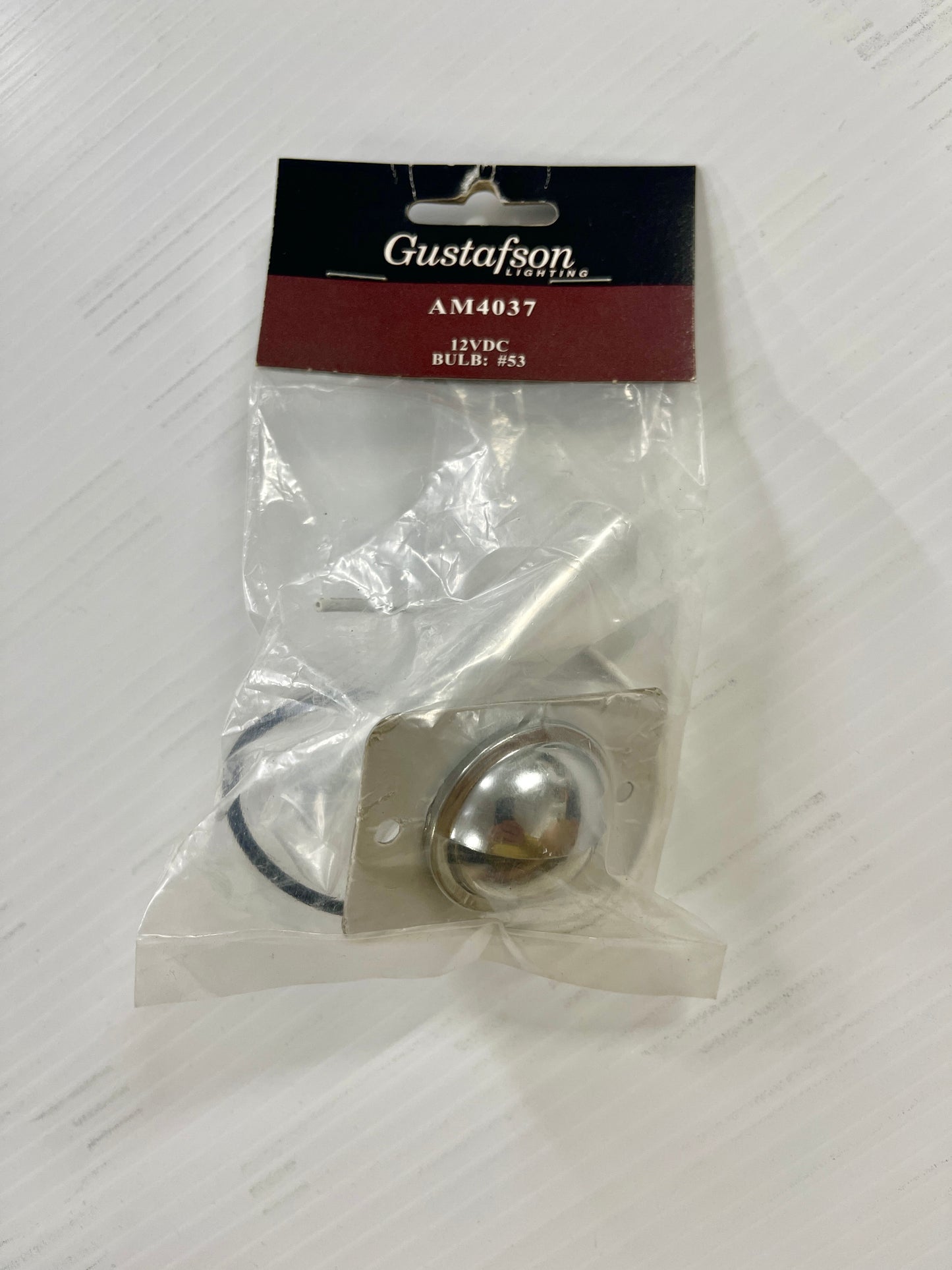 A Gustafon brand AM4037 12VDC courtesy light bulb in retail packaging.