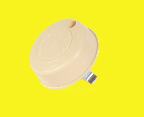 A beige colored plastic cap for a plumbing vent with clamps on a yellow background.