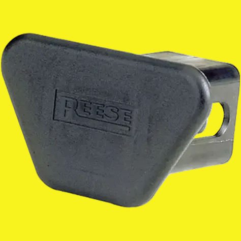 A black plastic Reese trailer hitch cover with the Reese brand embossed on the front, shown on a plain yellow background.