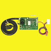 A green electronic circuit board with attached black and red wires, shown on a plain yellow background.