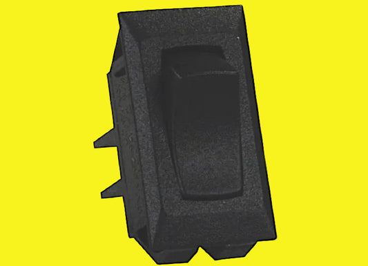 A black molded plastic toggle switch with a textured surface and a central rectangular button, shown on a plain yellow background.