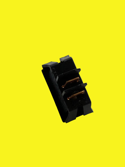 A black electrical switch with two terminals on a yellow background.