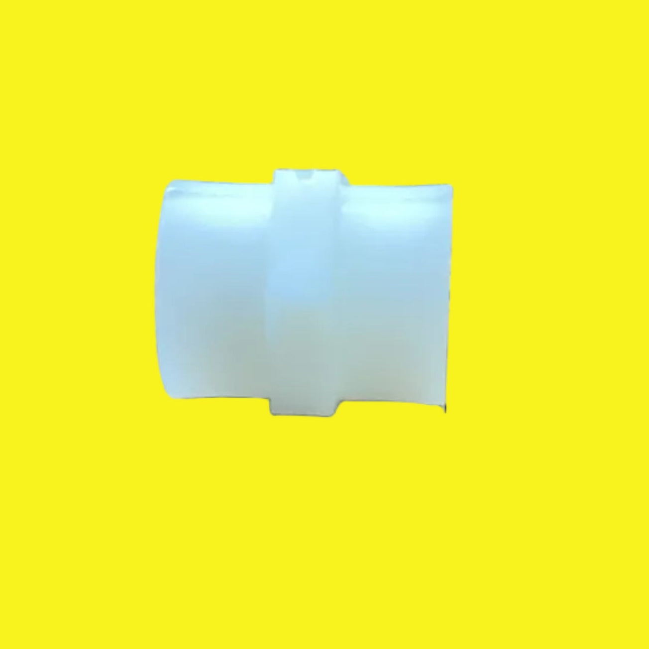 A small translucent white plastic connector piece placed on a yellow background.