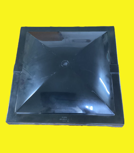 The top of a square black roof vent cover on a yellow background.