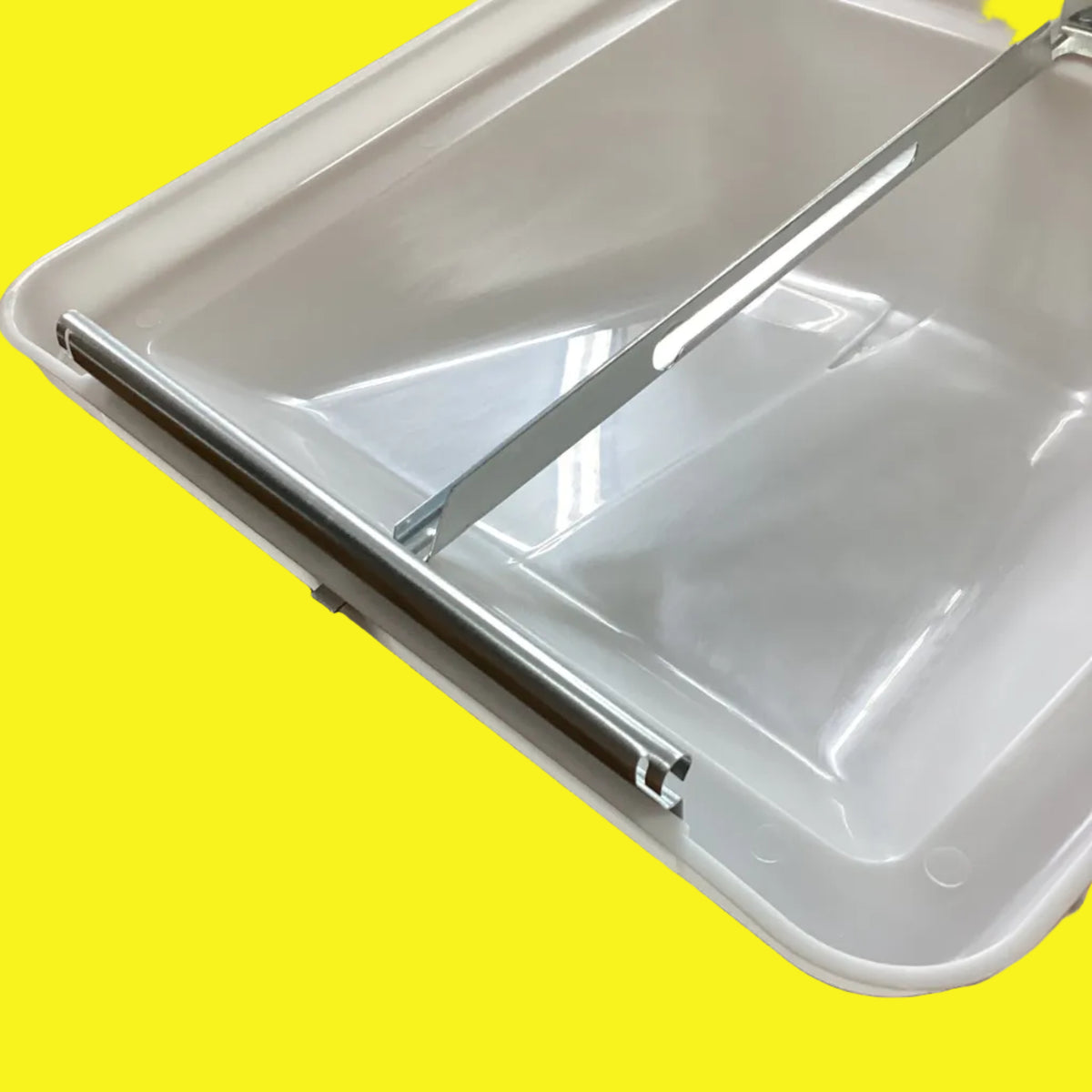 The bottom side of a white roof vent lid showing a notched hinge