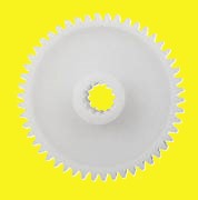A round white disk with a hole in the center and teeth around the edge
